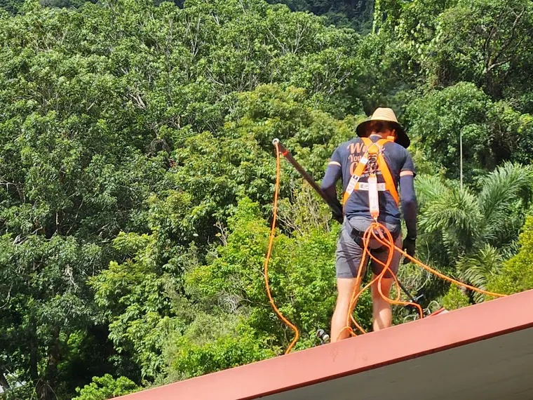Wish You Were Clear technician harnessed for roof-level access