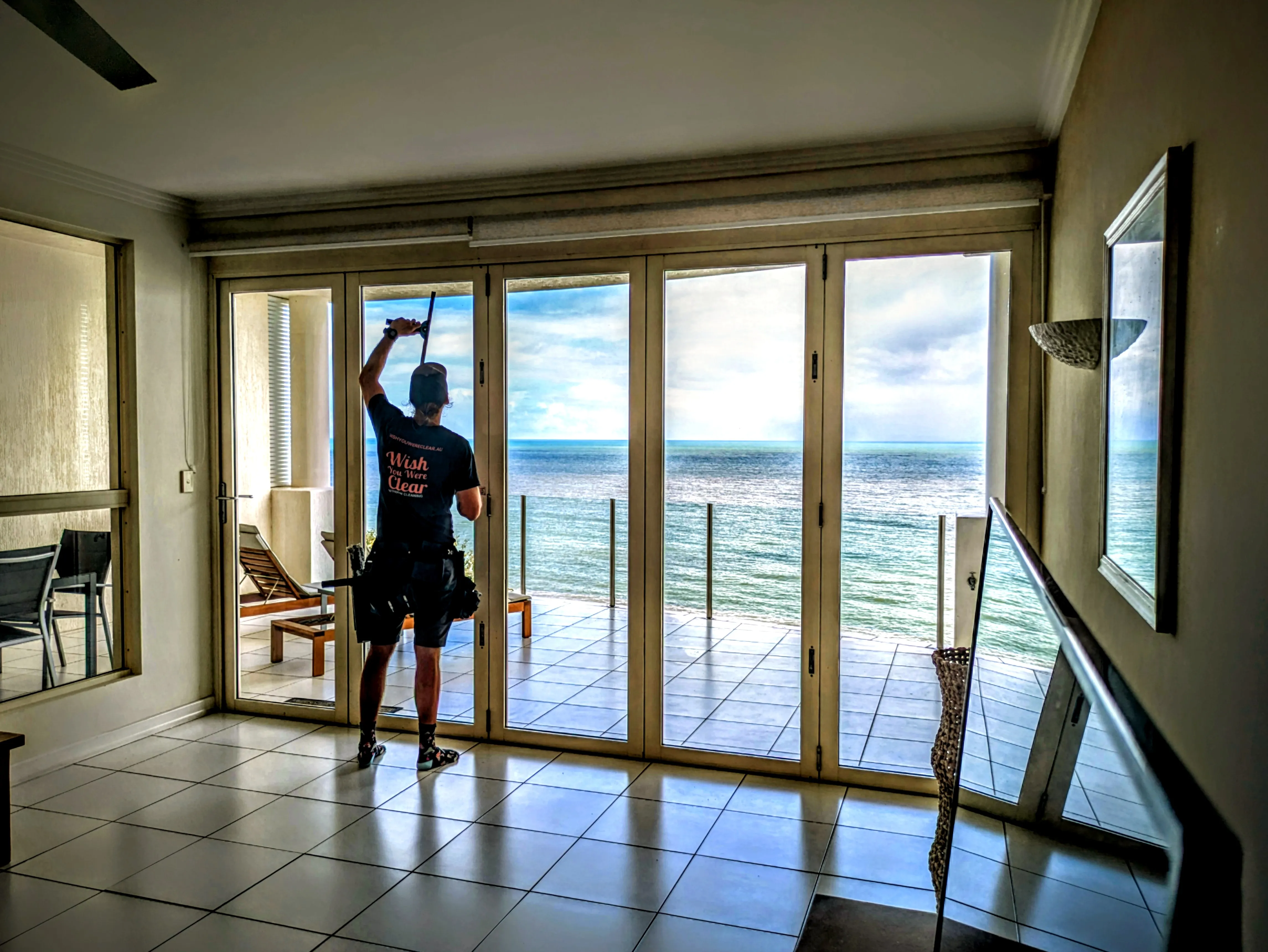 Looking out through freshly cleaned bifold glass doors to the Coral Sea from a Cairns oceanfront home
