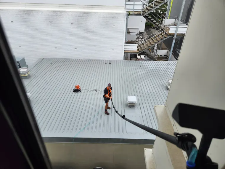 Wish You Were Clear technician harnessed on a commercial rooftop