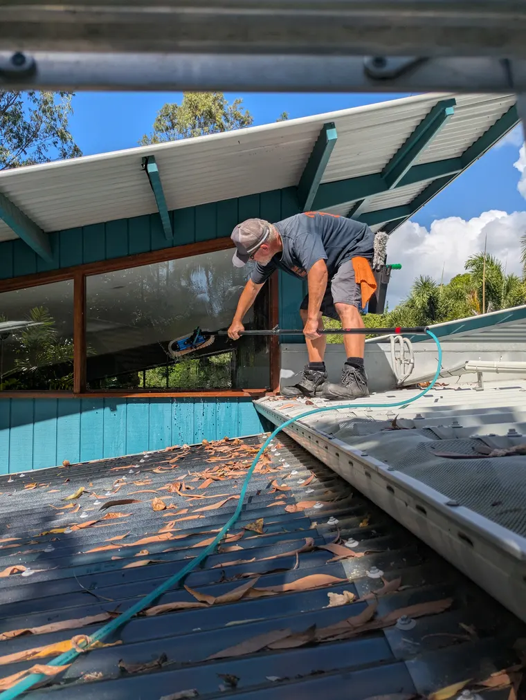 Wish You Were Clear technician working carefully on a roofline of a Cairns home