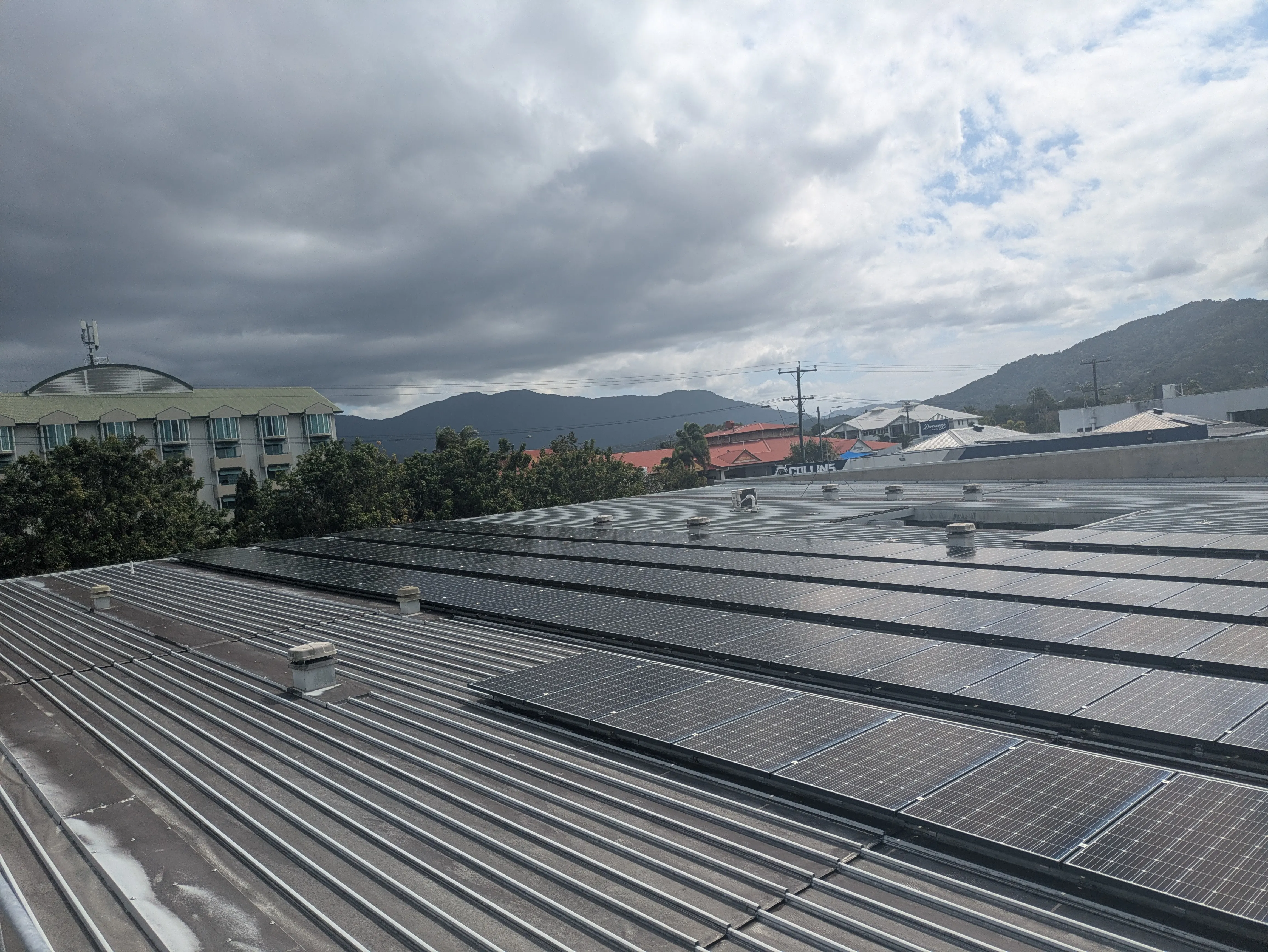 Solar panel array on a Cairns roof with mountains in the background