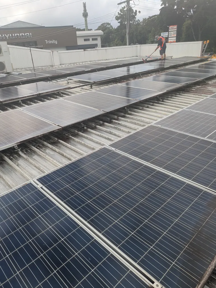 Wish You Were Clear technician using a solar brush and pole to clean a dirty rooftop array